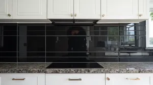 Czarne płytki między szafkami w kuchni